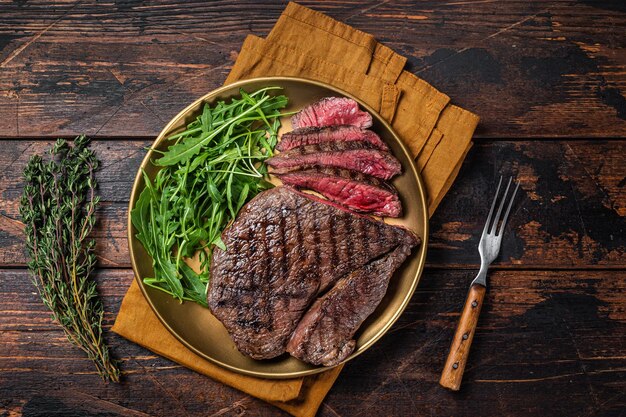 Dîner barbecue avec steak de boeuf haut de surlonge et salade sur une assiette Fond en bois Vue de dessus