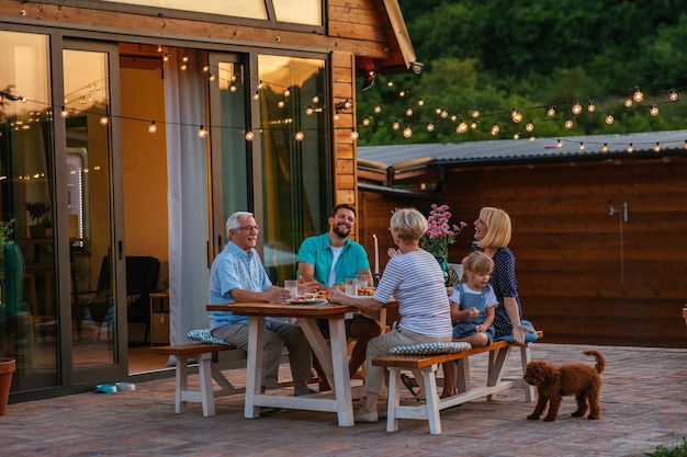 Photo dîner en famille autour d'une table à manger dans le jardin