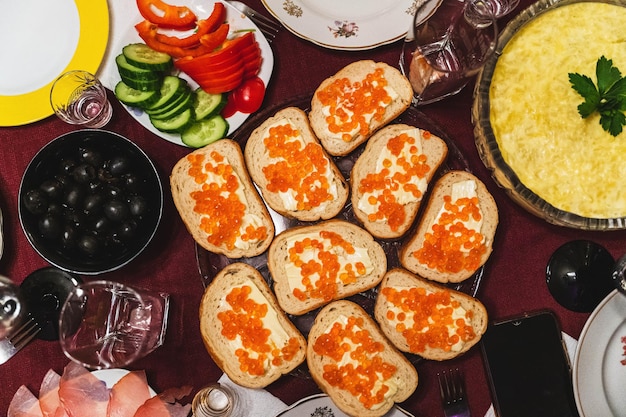 Dîner de fête fait maison avec des sandwichs caviar rouge beurre olives