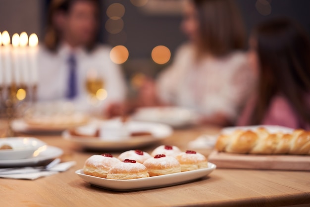 Dîner de Hanoucca. Famille réunie autour de la table avec des plats traditionnels