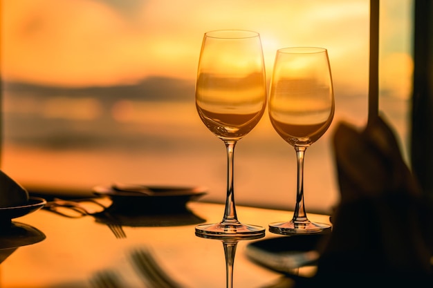 Dîner de luxe romantique. Verres vides et coucher de soleil tropical avec fond de mer. Soirée romantique avec magnifique coucher de soleil.