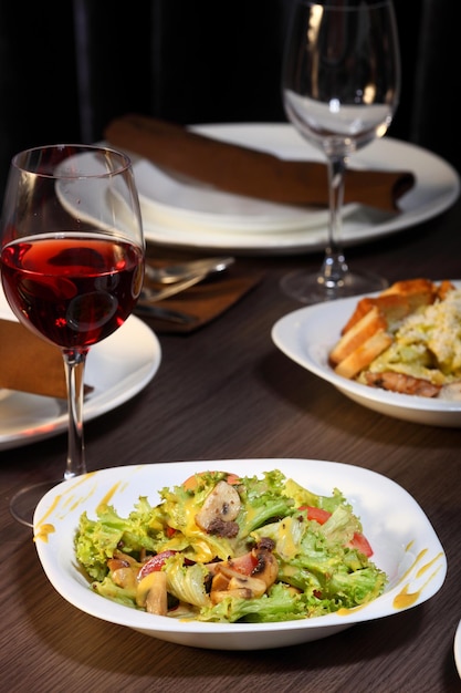 Dîner de luxe servi sur la table avec verre de vin rouge