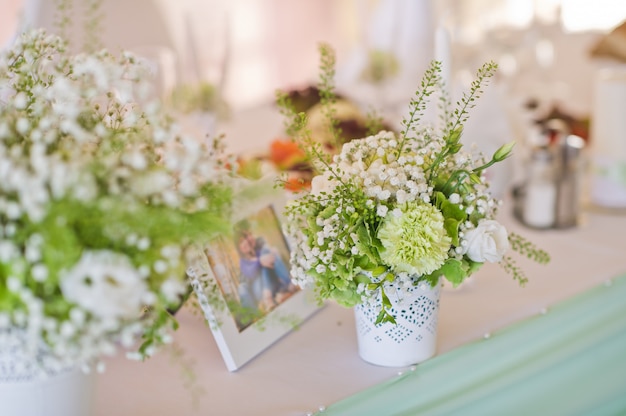 Dîner de mariage, la table des mariés décorée de fleurs.