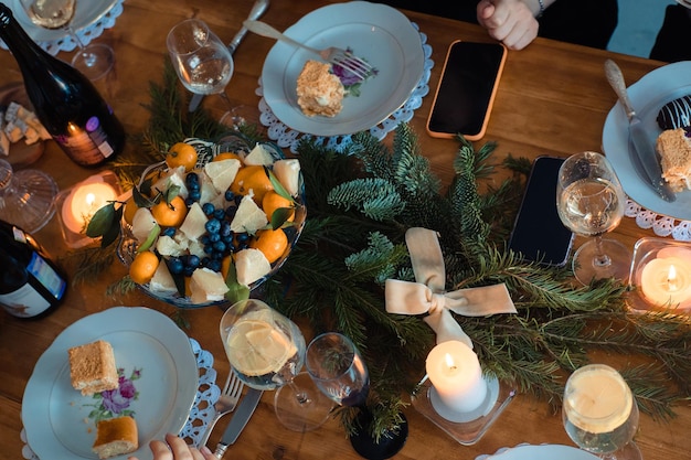 Dîner de Noël avec des bougies de mandarines et des branches d'épinette pour la décoration