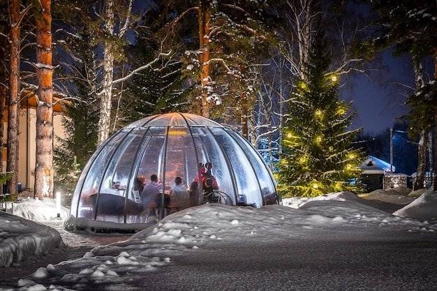 Dîner en plein air dans une bulle par temps hivernal, beaucoup de neige autour pour favoriser la distanciation sociale.