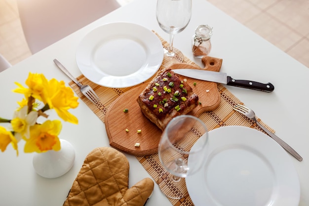 Dîner pour deux servi dans la cuisine viande rôtie avec vin dans la salle à manger