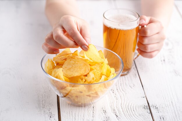 Dîner relax avec bière et chips de pomme de terre, femme à la maison