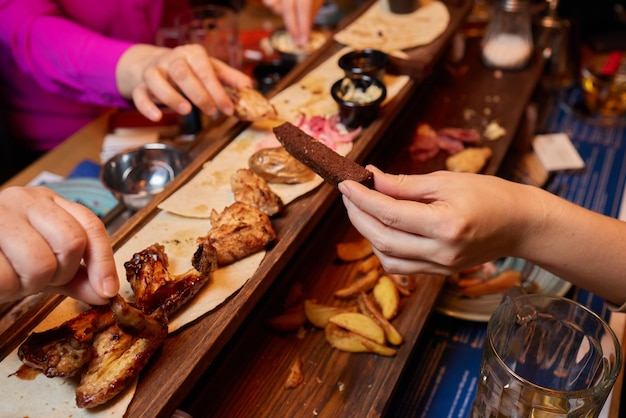 Dîner de restauration rapide familial Lockdown du service de livraison Flatlay d'un groupe d'amis mangeant des hamburgers frites sandwichs pizza buvant de la bière à la fête à la maison sur fond de table vue de dessus