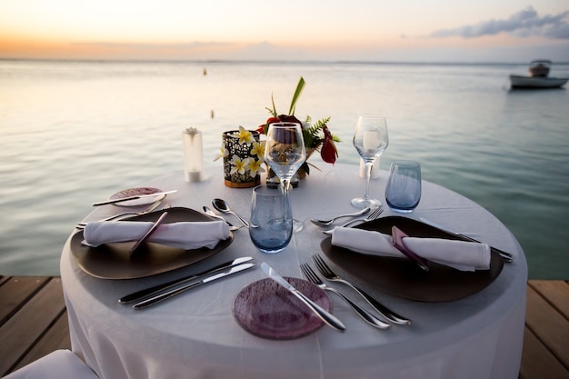 Dîner romantique sur la plage au coucher du soleil