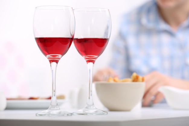 Dîner avec des verres de vin sur fond flou clair