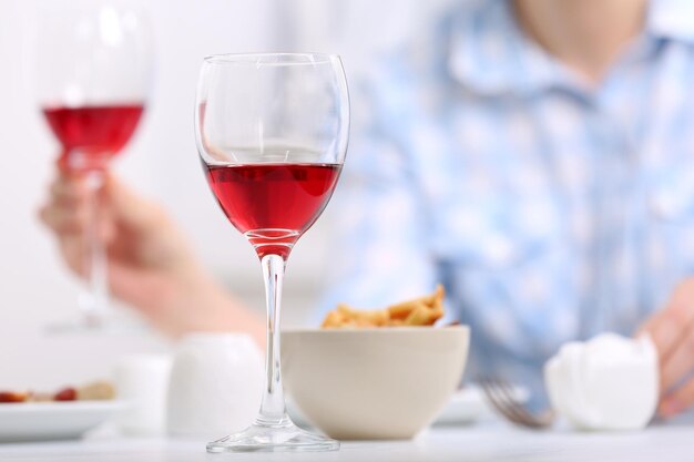 Dîner avec des verres de vin sur fond flou clair