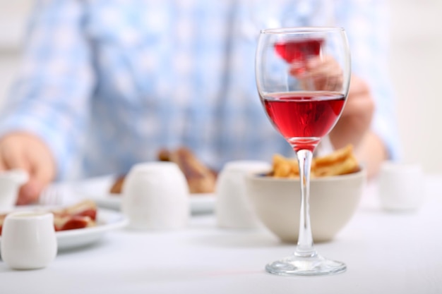 Dîner avec des verres de vin sur fond flou clair