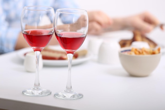 Dîner avec des verres de vin sur fond flou clair