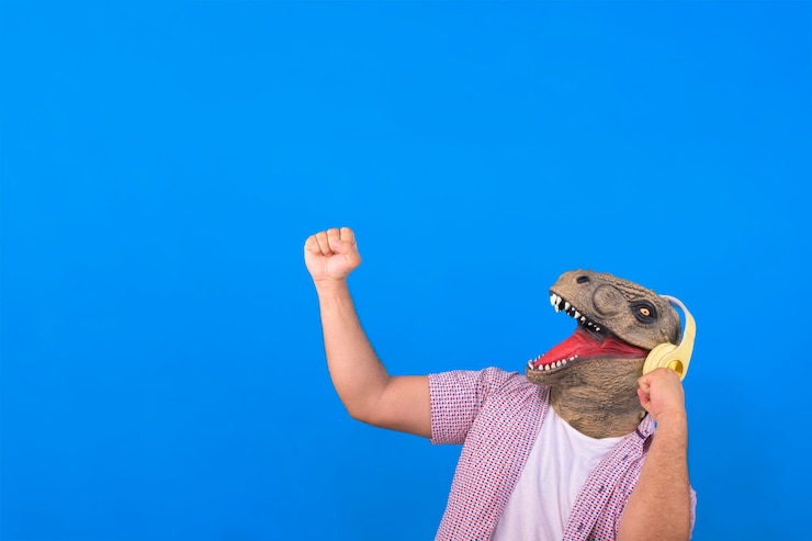 Photo dinosaure avec corps humain écoutant de la musique sur un fond bleu isolé