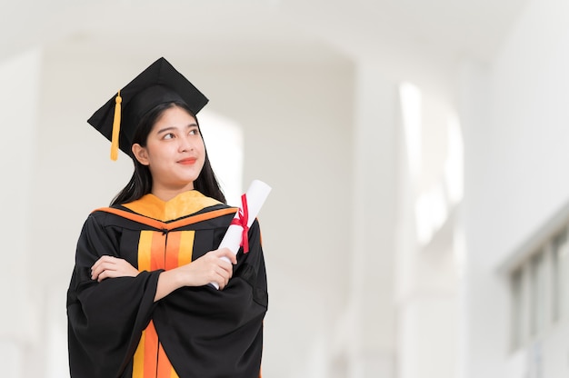 Diplômées universitaires portant des chapeaux noirs, des glands jaunes, souriant et heureux le jour de la remise des diplômes