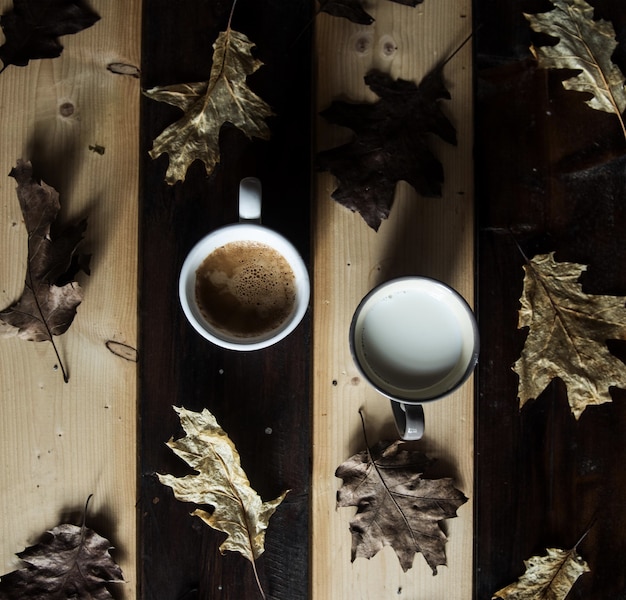 Directement au-dessus du café et du lait au milieu des feuilles sèches sur la table