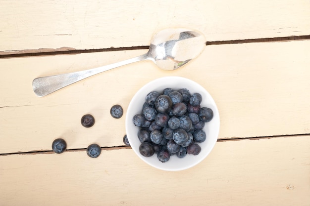 Photo directement au-dessus de la photo de bleuets dans un bol par cuillère sur la table