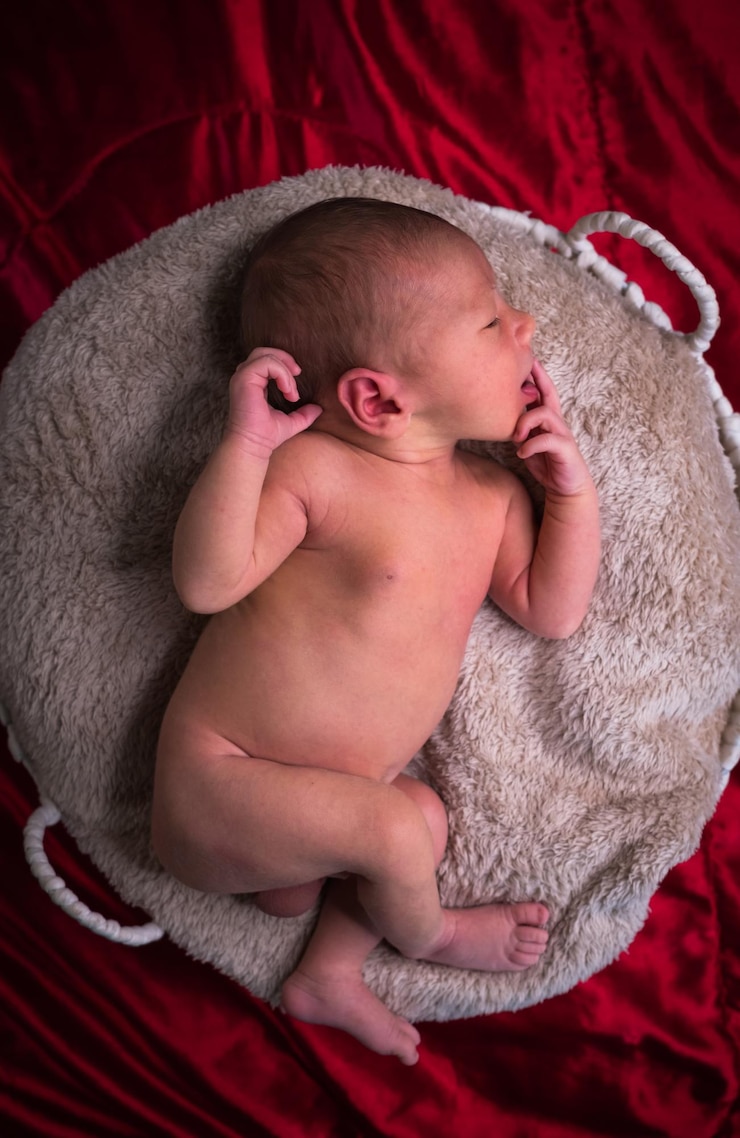 Photo directement au-dessus de la photo d'un mignon nouveau-né qui dort sur le lit à la maison