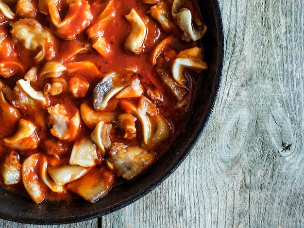 Photo directement au-dessus de la photo des oreilles de cochon dans la sauce tomate sur une table en bois