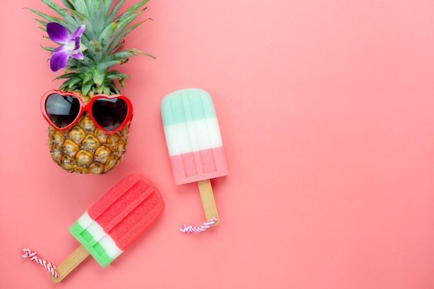 Directement au-dessus de la prise de vue de crèmes glacées aromatisées et d'ananas sur fond rose