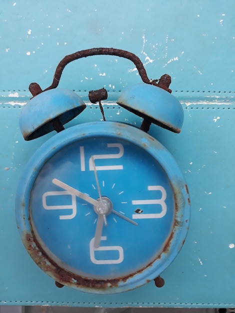 Photo directement au-dessus de la prise de vue de l'horloge altérée sur la table bleue