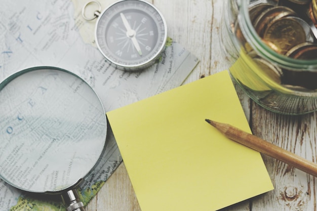 Photo directement au-dessus de la prise de vue d'une note collante en blanc au crayon et à la loupe sur la table