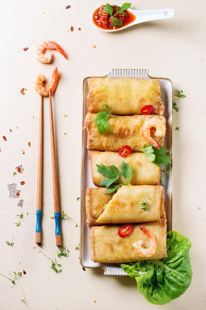 Photo directement au-dessus, des rouleaux de printemps frits avec des crevettes sur une table en bois.