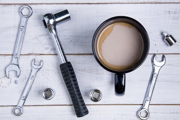 Photo directement au-dessus de la tasse de thé au milieu des outils de travail sur la table