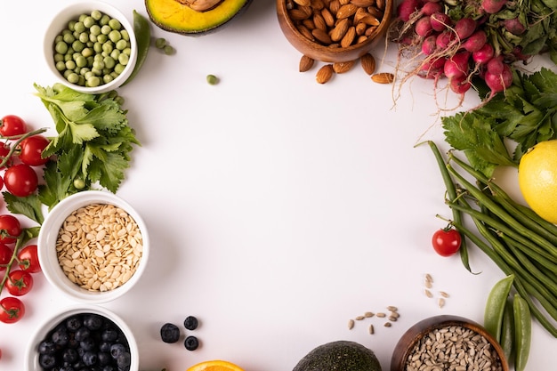 Directement au-dessus de la vue de l'espace de copie entouré de divers aliments frais sur fond blanc. inchangé, nourriture, alimentation saine, concept biologique.