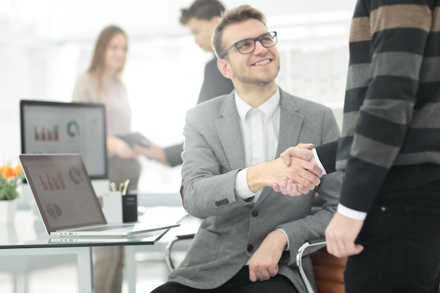 Le directeur et le client se serrent la main lors de leur rencontre au bureau