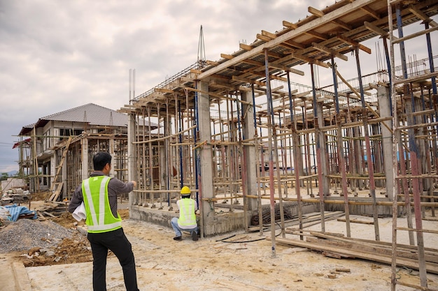 directeur de la construction et ingénieur en papier de plans de casque de protection à portée de main sur le chantier