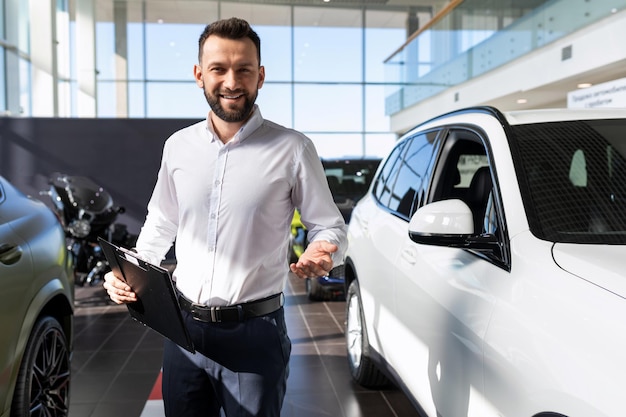 Le directeur du concessionnaire automobile accueille l'acheteur avec le sourire