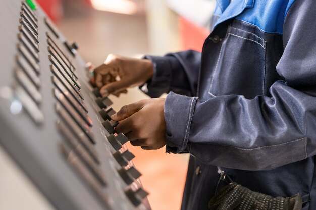 Photo directeur industriel avec tablette parlant au travailleur et examinant les pièces métalliques produites dans l'atelier d'usine