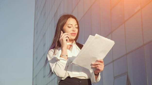 Le directeur marche en parlant au téléphone et en regardant des documents