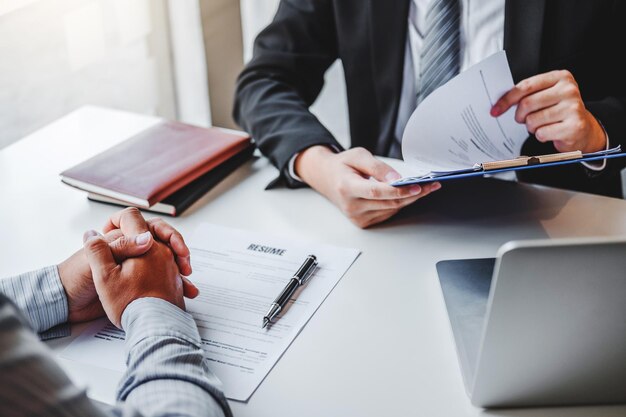 Photo un directeur des ressources humaines senior lit un cv lors d'un entretien d'embauche, un employé rencontre un jeune homme, un demandeur d'emploi et un recrutement.