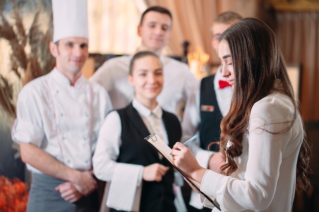 Photo directeur de restaurant et son personnel dans la cuisine. interagir avec le chef cuisinier dans la cuisine commerciale.