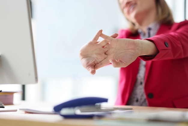 Un directeur satisfait étend les bras après une paperasserie monotone dans une femme de bureau en veste écarlate