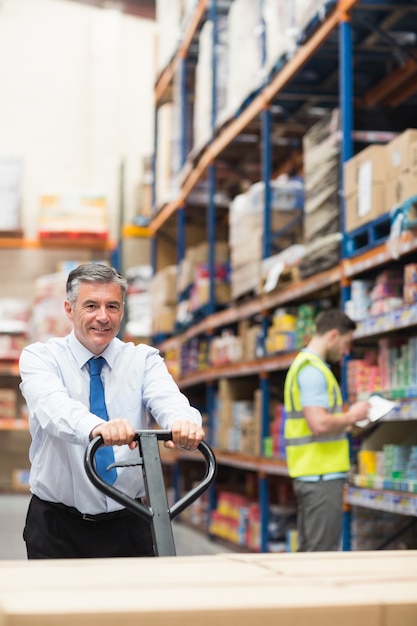 Directeur tirant le chariot avec des boîtes devant son employé