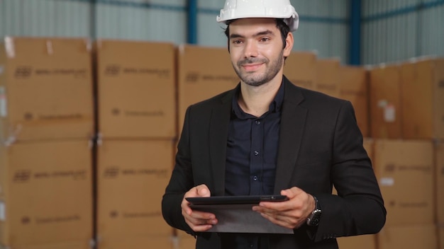 Directeur d'usine à l'aide d'un ordinateur tablette dans un entrepôt ou une usine. Concept de gestion de l'industrie et de la chaîne d'approvisionnement.