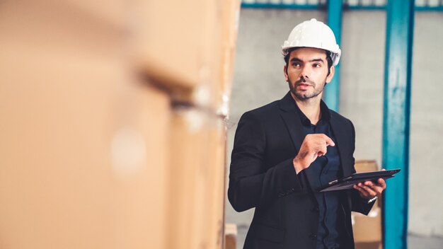 Directeur d'usine à l'aide d'une tablette dans l'entrepôt