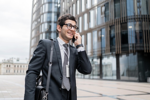 Le directeur utilise le téléphone pour parler au client un homme avec des lunettes va au bureau pour travailler