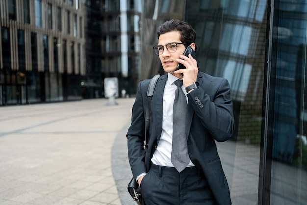 Le directeur utilise le téléphone pour parler au client un homme avec des lunettes va au bureau pour travailler