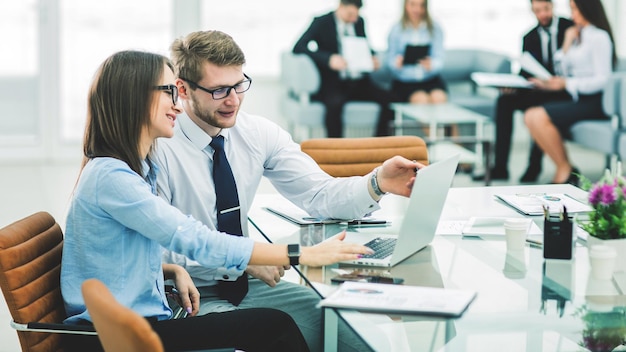 Le directeur des ventes et le comptable travaillent sur un ordinateur portable avec des tableaux financiers de l'entreprise