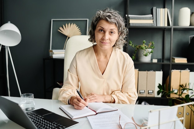 Directrice expérimentée d'une entreprise qui vous regarde avec le sourire