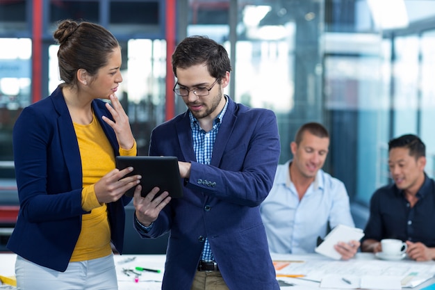 Dirigeant d'entreprise mâle et femelle discutant sur tablette numérique