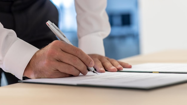 Dirigeant d'entreprise signant un document ou un contrat à l'aide d'un stylo à encre
