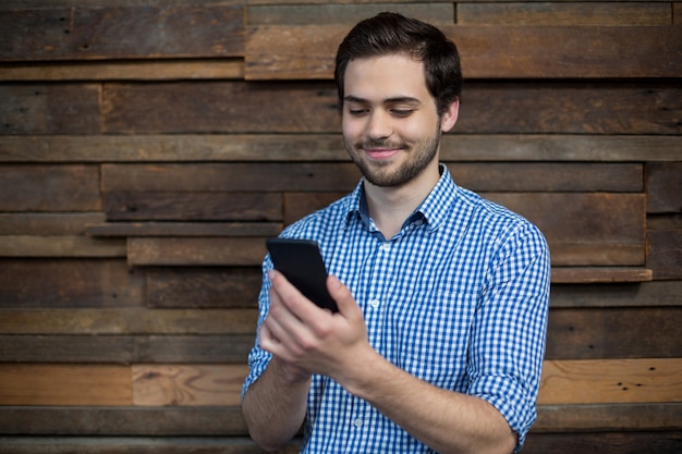 Dirigeant d'entreprise souriant à l'aide de téléphone portable