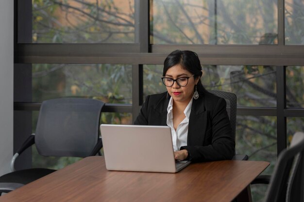 Photo une dirigeante mexicaine travaille sur son ordinateur portable dans un bureau avec un espace de copie