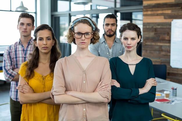 Dirigeants d'entreprise debout, les bras croisés au bureau