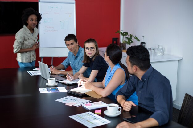 Les dirigeants d'entreprise discutant sur le tableau de conférence pendant la réunion